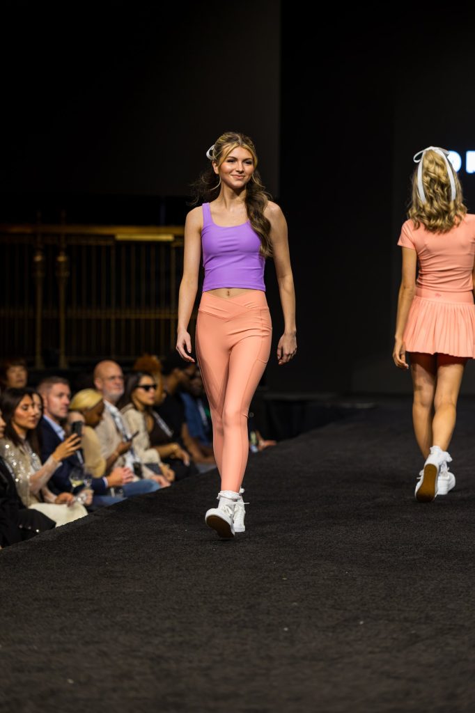 Carissa, Tone Talent Agency model, walking the runway in a purple top and coral leggings