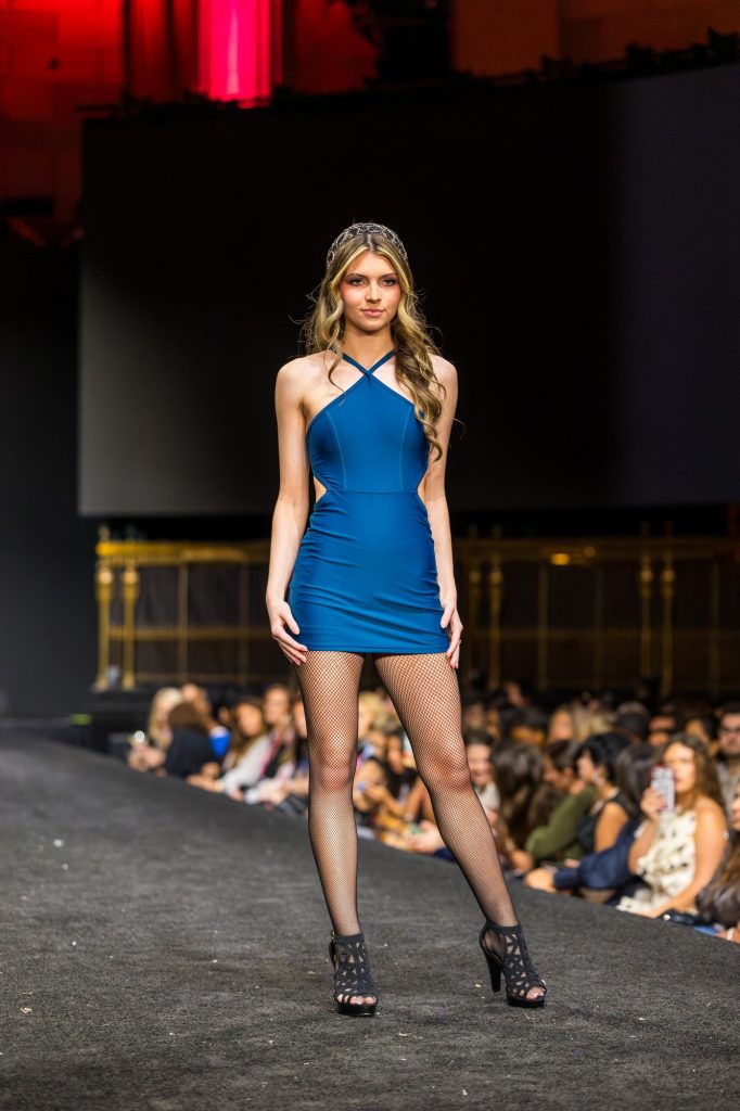 Carissa, Tone Talent Agency model, on the runway in a blue halter mini dress